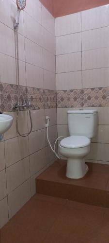 a bathroom with a toilet and a sink at Taras Homestay in Seribu