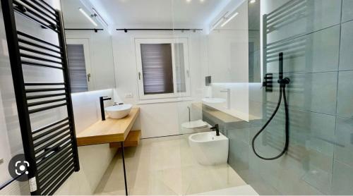 a bathroom with two toilets and a glass shower at Nature Apartment in Olbia