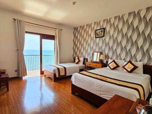 Habitación de hotel con 2 camas y balcón en Venus Phu Quoc Hotel, en Phu Quoc
