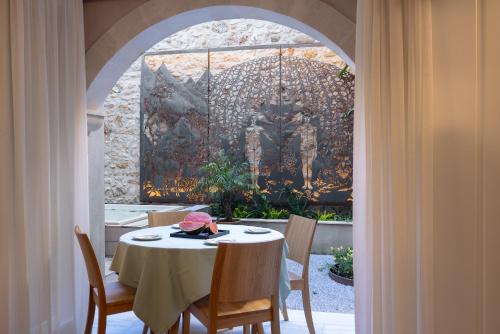 a table and chairs in a room with an archway at Rimondi Residences Rethymno in Rethymno Town