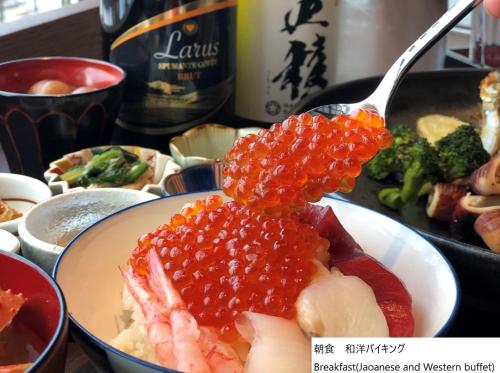 un piatto di cibo con carne e verdure e un cucchiaio di La Vista Hakodate Bay Annex a Hakodate