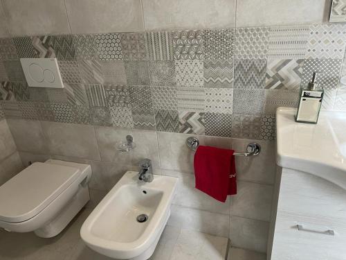 a bathroom with a white toilet and a sink at Perla Top Floor Apartment in Sirmione