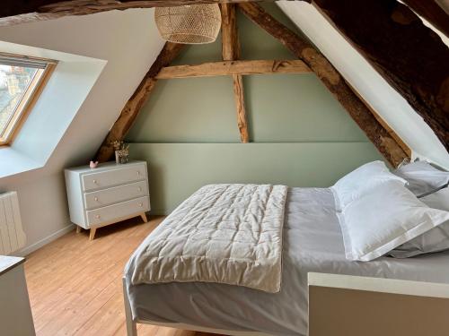 Schlafzimmer mit einem Bett und Holzboden in der Unterkunft Le Clos des écureuils in Audrieu