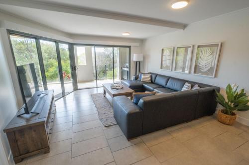 a living room with a couch and a tv at Pavillions on 1770 in Agnes Water
