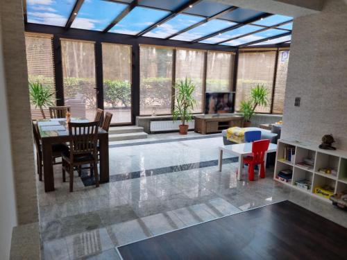 a living room with glass ceilings and a table and chairs at Apartament BURSZTYNEK in Pobierowo