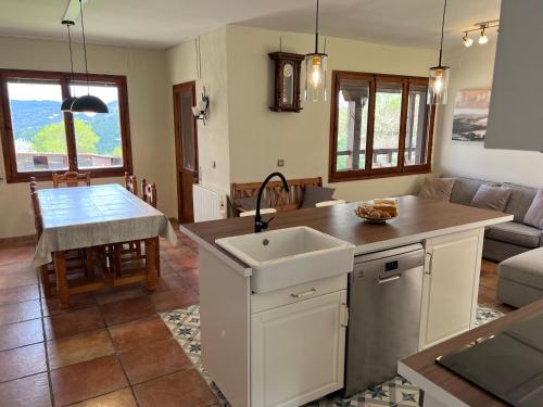 uma cozinha e sala de estar com um lavatório e uma mesa em Casa rural completa en plena naturaleza em Eguíllor