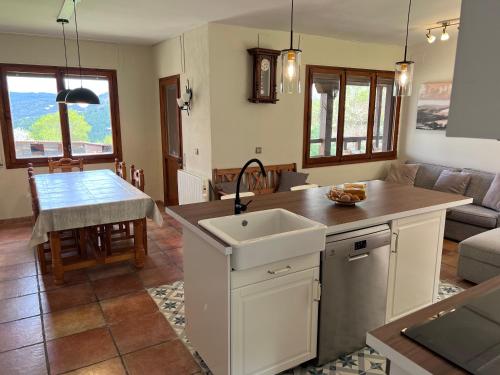 een keuken en een woonkamer met een wastafel en een tafel bij Casa rural completa en plena naturaleza in Eguíllor