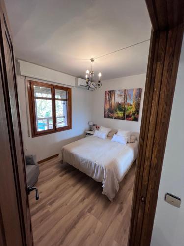 een slaapkamer met een groot bed en een kroonluchter bij Casa rural completa en plena naturaleza in Eguíllor