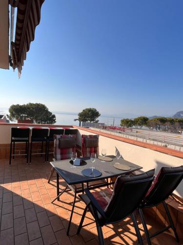 a table and chairs on a patio with a view of the beach at Favola Bella The panoramic penthouse in Bardolino