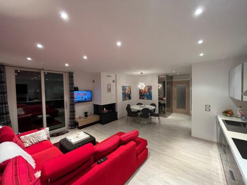 a living room with a red couch and a kitchen at Favola Bella The panoramic penthouse in Bardolino
