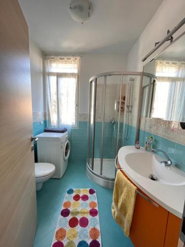 a bathroom with a sink and a shower and a toilet at Favola Bella The panoramic penthouse in Bardolino