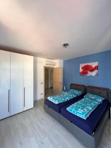 a bedroom with a bed and a blue wall at Favola Bella The panoramic penthouse in Bardolino