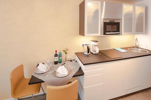 a small kitchen with a table and a counter top at Top Appartements Roth am Strande in Westerland (Sylt)