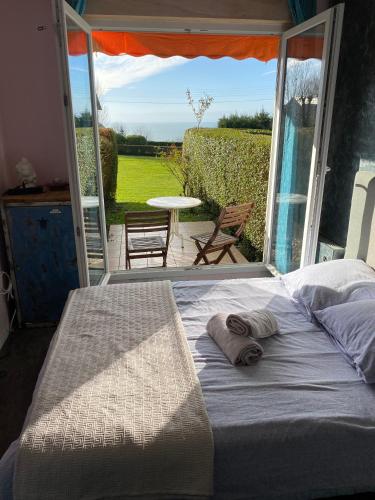 Ce lit se trouve dans un dortoir avec vue sur la terrasse. dans l'établissement Studio cosy et terrasse-jardin superbe vue mer, à Trouville-sur-Mer