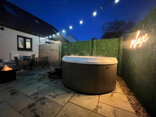 a bath tub sitting on a patio at night at Birch Cottage in Tenby