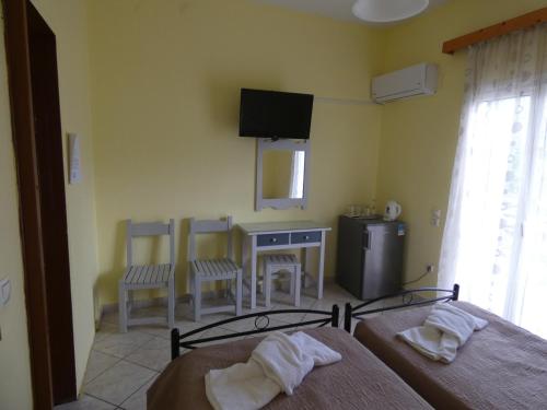 a bedroom with two beds and a table and chairs at Dixtia Apartments in Agios Georgios Pagon