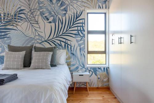 a bedroom with a bed with a blue and white wallpaper at The Whalehouse in Wilderness