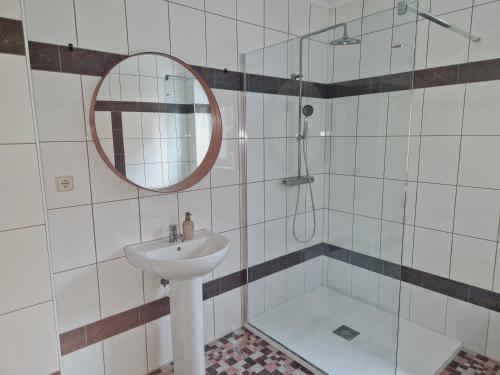 a bathroom with a sink and a shower with a mirror at Apartmány Skalka in Terchová