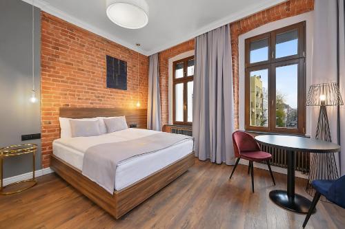 sypialnia z łóżkiem i ceglaną ścianą w obiekcie Aparthotel Krzywa Kamienica w Łodzi