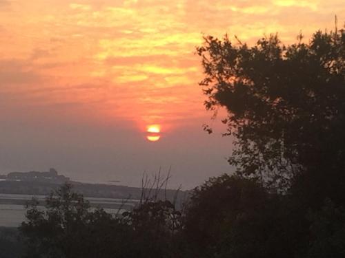 a sunset with the sun in the sky at Above the Sea in ‘En Hod