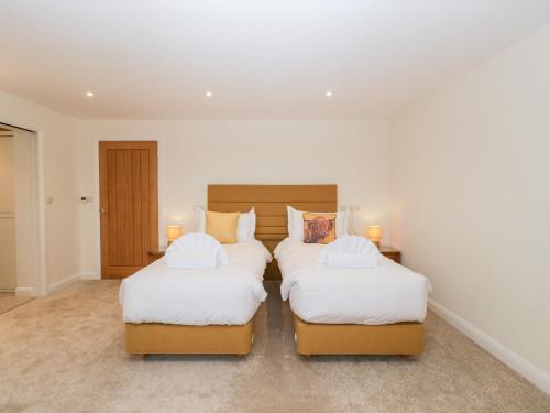 two twin beds in a room with white walls at Bilsham Meadows in Bristol
