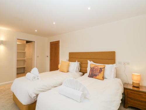 a bedroom with two beds with white sheets at Bilsham Meadows in Bristol