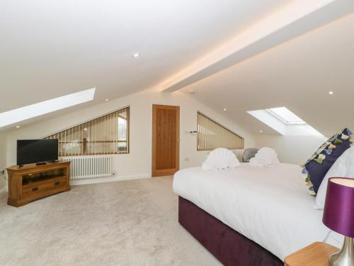 a bedroom with a large bed and a flat screen tv at Bilsham Meadows in Bristol