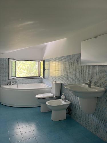 een badkamer met een bad, een toilet en een wastafel bij Villa Green garden in Carlentini