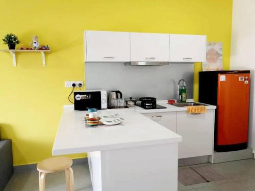 een keuken met een wit aanrecht en een rode koelkast bij KA701-One Bedroom Apartment- Wifi -Netflix -Parking - Pool, 1002 in Cyberjaya