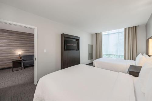 a hotel room with two beds and a flat screen tv at Residence Inn Franklin Berry Farms in Franklin