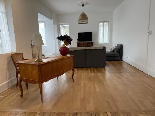 ein Wohnzimmer mit einem Tisch und einem Sofa in der Unterkunft Appt 130m2-Jusqu'à 3 Chambres-Centre ville-Moulins-Le Pal in Moulins