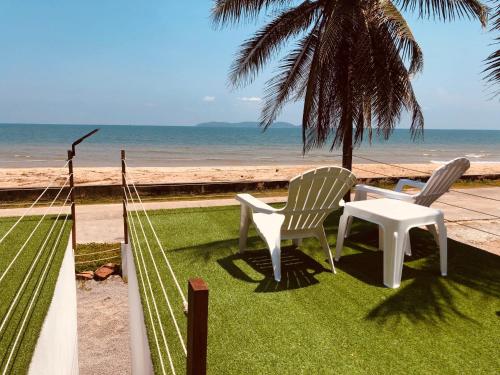 2 sillas y una mesa junto a la playa en Sabai Villa, 