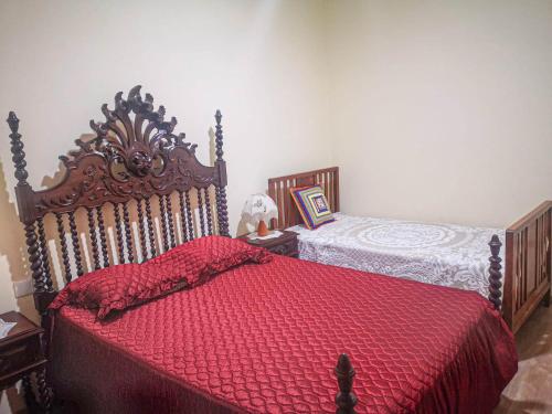 um quarto com uma cama com um edredão vermelho em Casa do Rosa - Santana de Cambas em Santana de Cambas