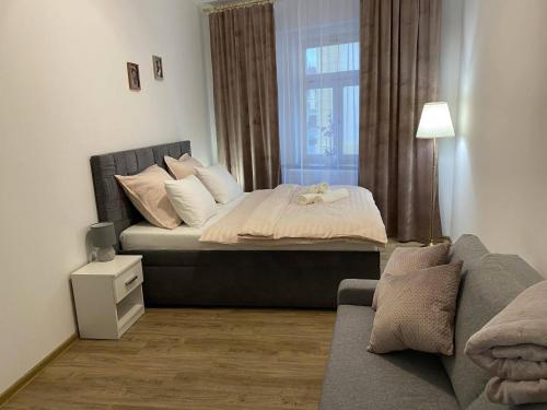 1 dormitorio con 1 cama con sofá y ventana en Stylový byt v srdci Hradce Králové en Hradec Králové