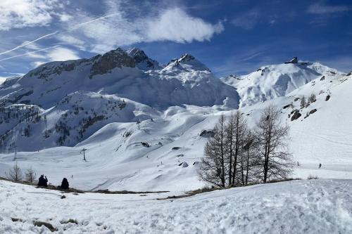 two people sitting on a snow covered mountain at Grand studio à Ovronnaz in Ovronnaz