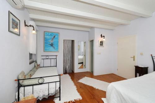 a white room with two beds and a hallway at Villa Nikolina in Molat