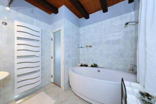 a white bathroom with a tub and a sink at Villa Nikolina in Molat