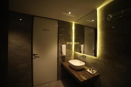 a bathroom with a sink and a mirror at Hotel Midland, Nanded in Nānded