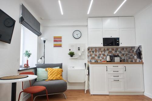 Cette chambre comprend une petite cuisine avec une table et une chaise. dans l'établissement Розкішні апартаменти - парк Олександрія, кава, чай, wifi, à Bila Tserkva