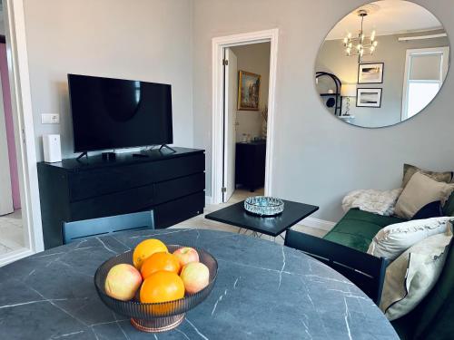 a living room with a bowl of fruit on a table at Castle Inn Apartments - Downtown Keflavík in Keflavík