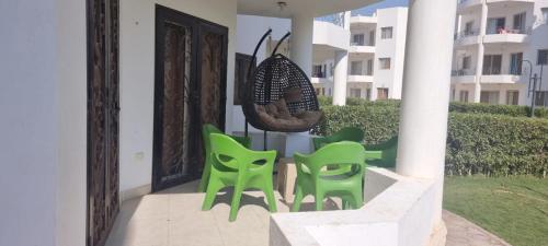 a group of green chairs sitting on a porch at شيماء كسل in Cairo
