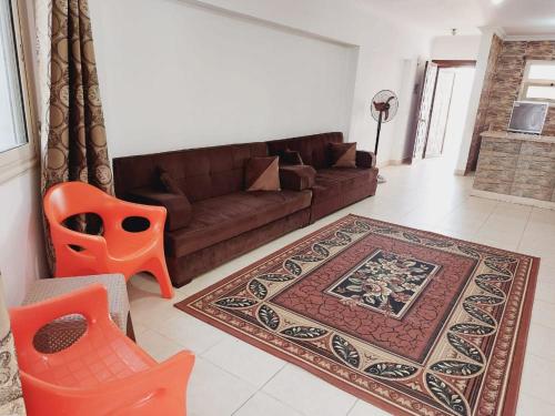 a living room with a brown couch and a rug at شيماء كسل in Cairo