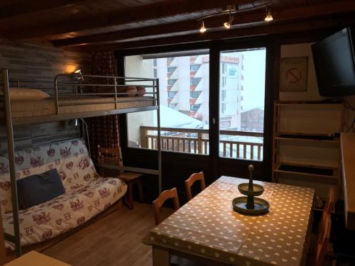 Cette chambre comprend une table et des lits superposés. dans l'établissement Val Thorens , apt Lac Blanc, à Val Thorens