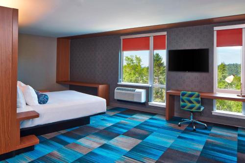 a hotel room with a bed and a desk at Aloft Seattle Redmond in Redmond