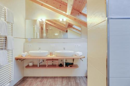 a bathroom with two sinks and a mirror at Ferienwohnung Partnachklamm in Garmisch-Partenkirchen
