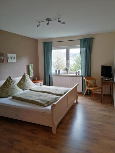 a bedroom with a bed and a desk and a window at Ferienwohnung Klaus in Treis-Karden