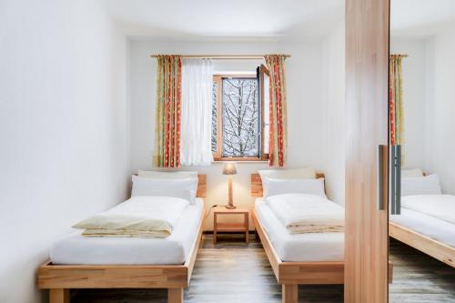 two beds in a room with a window at Ferienwohnung Geroldsee in Garmisch-Partenkirchen