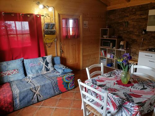a living room with a bed and a table with a table at Apartma Suzy in Pobegi