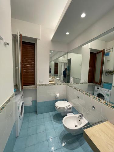 uma casa de banho com 2 WC, um lavatório e um espelho. em Smeraldo em Maiori
