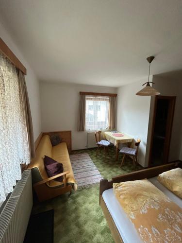 Cette chambre comprend un lit, une table et un canapé. dans l'établissement Haus Gletscherblick, à Gschnitz